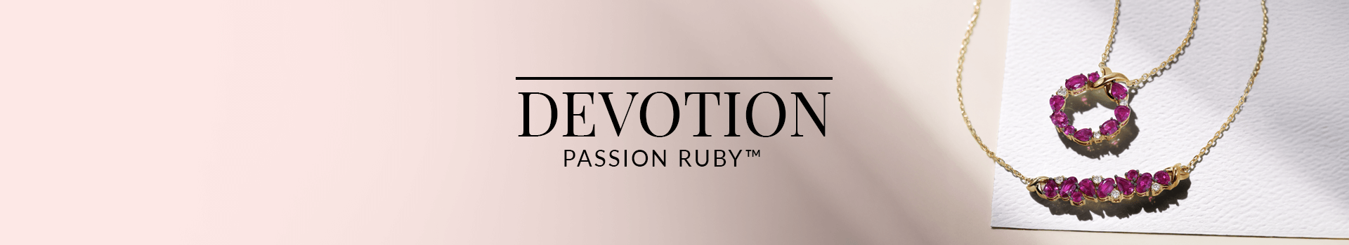 Two ruby and diamond necklaces—one in a heart motif and the other in a bar design—set in yellow gold and displayed on romantic stationery, from Le Vian’s Devotion Passion Ruby™ collection.