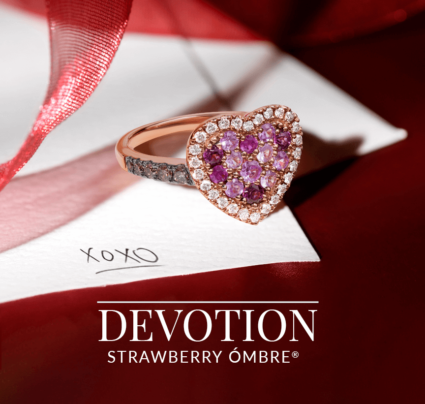 Heart-shaped pavé ring featuring a gradient of pink to purple gemstones surrounded by diamonds, resting on a love letter with pink ribbon, from Le Vian’s Devotion Strawberry Ombré® collection.