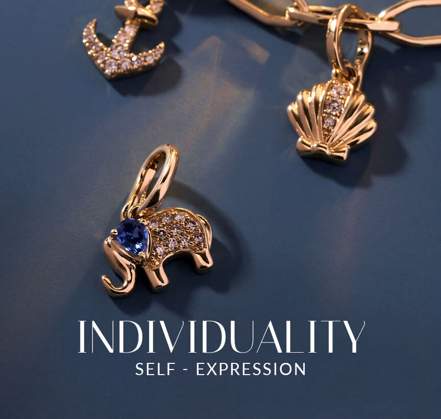 Le Vian® charm necklace featuring an elephant charm with a blue gemstone, plus shell and celestial charms on a blue surface.