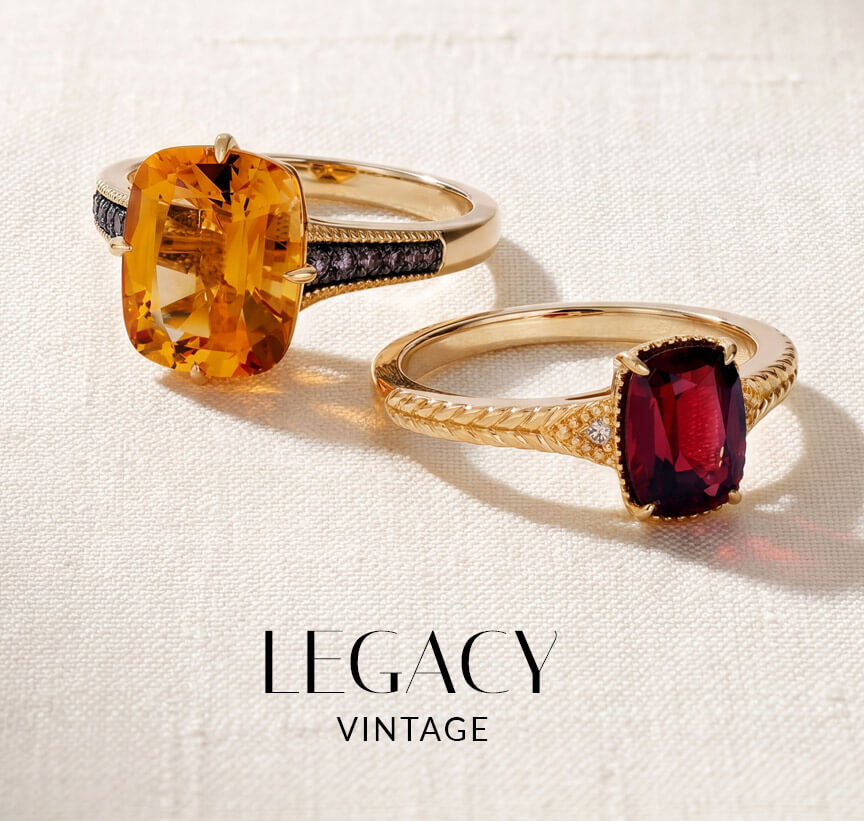 Two Le Vian® vintage-inspired gold rings with bold citrine and garnet center gemstones on textured white fabric.