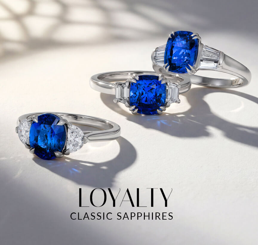 Three Le Vian® sapphire rings with diamond side stones in white metal on a softly lit white surface.