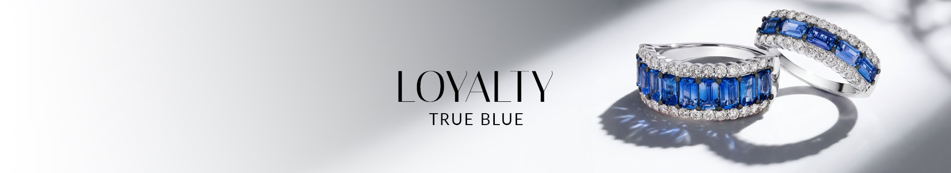 Two Le Vian® blue sapphire and diamond band rings in white metal on a softly lit white background.