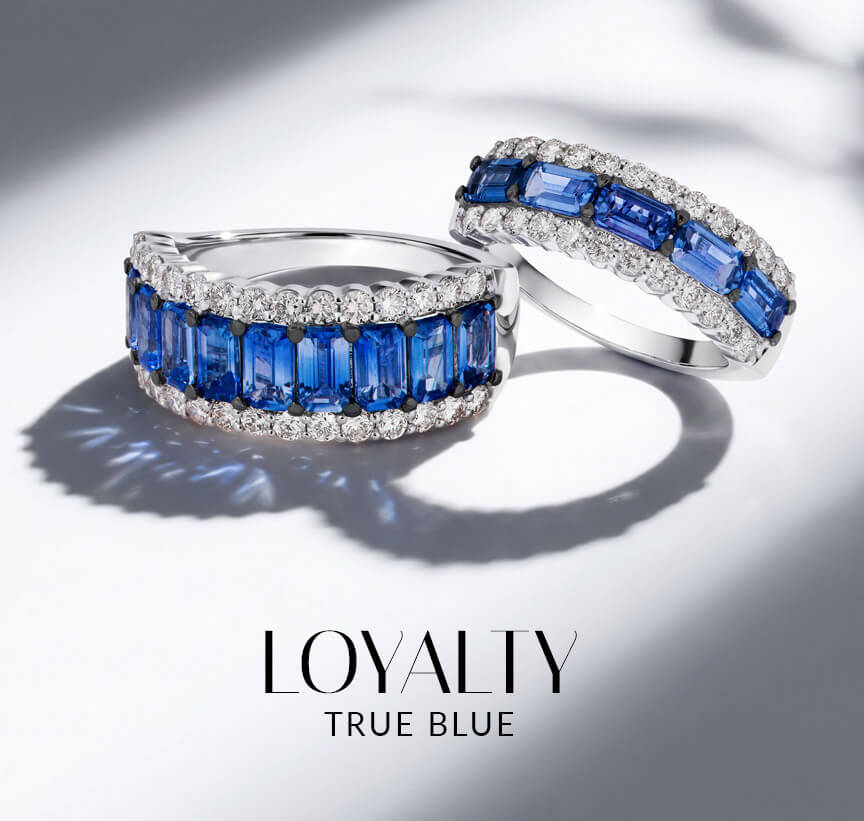 Two Le Vian® blue sapphire and diamond band rings in white metal on a softly lit white background.